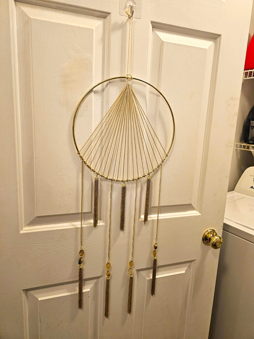 The House Doctor Dreams brass wall mobile features a geometric metal hoop design